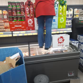 BİM Çalışanının Soğutucu Üzerinde Ayakkabıyla Çalışması Hijyen Endişesi Yarattı