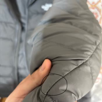 $285 North Face Jacket Shows Stitching, Stain, and Quality Defects